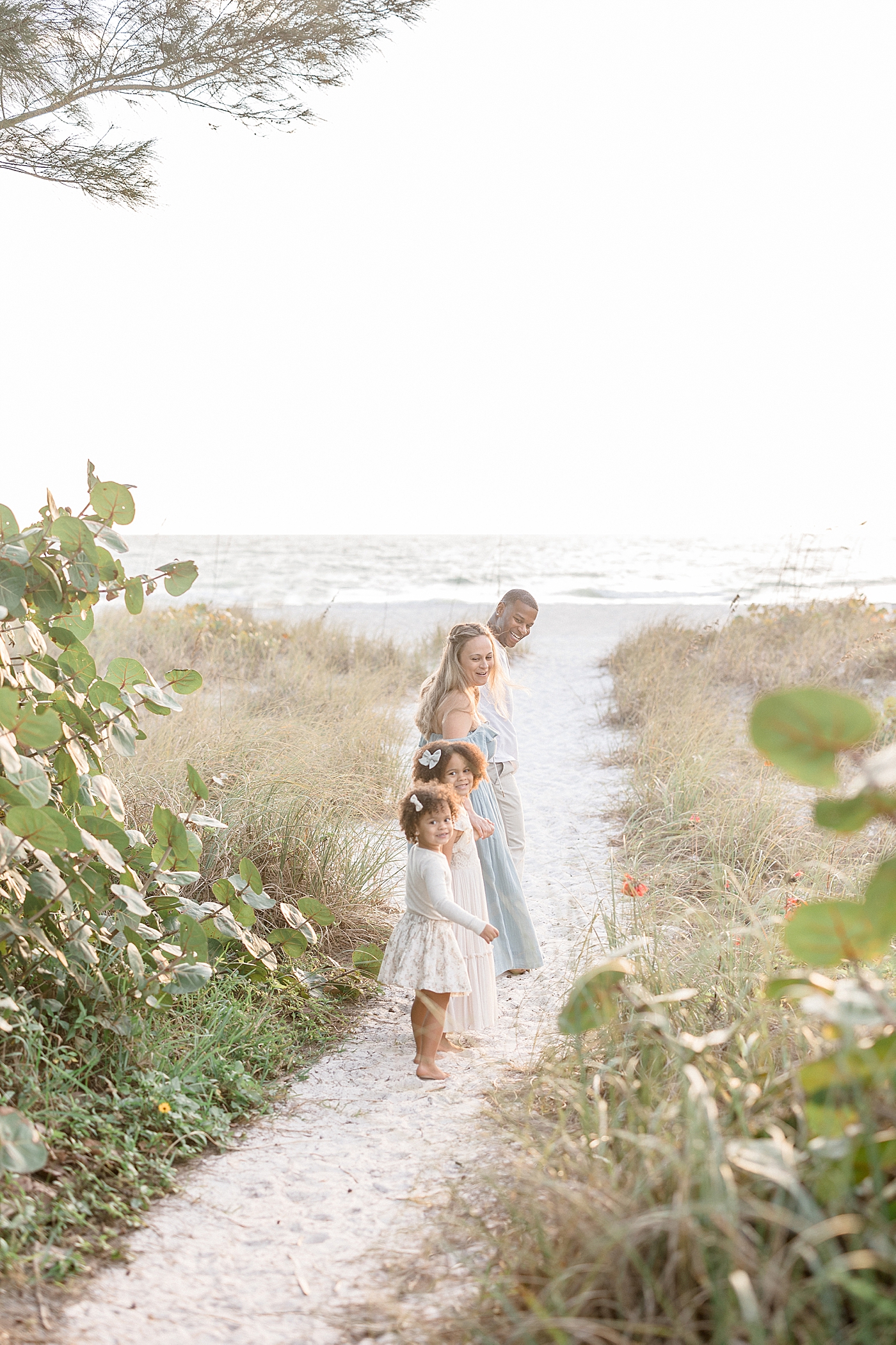 Family walking out to the beach at sunset for a photoshoot with Brittany Elise Photography.