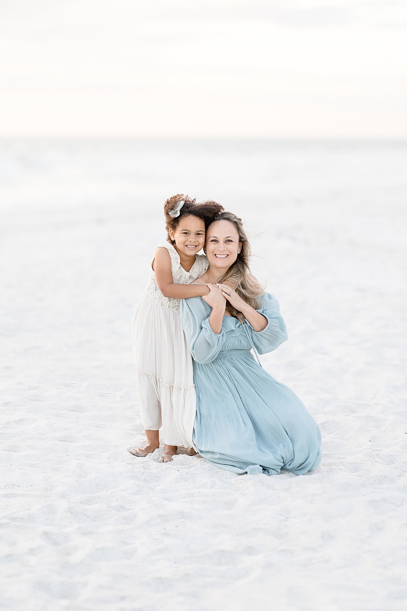 Mom and daughter on the beach together. Photo by Brittany Elise Photography.