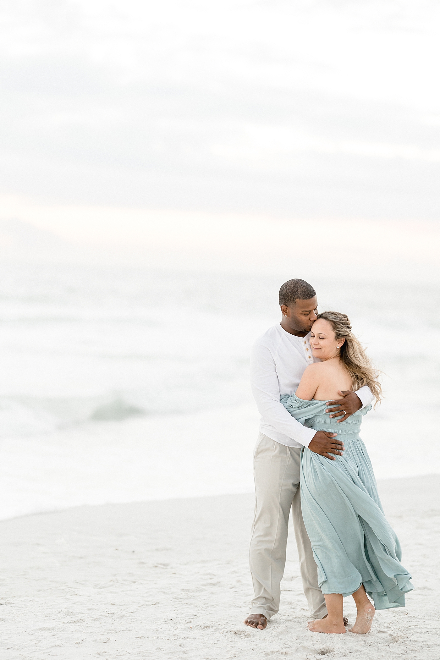 Sweet moment of two parents on the beach during family photoshoot with Brittany Elise Photography.