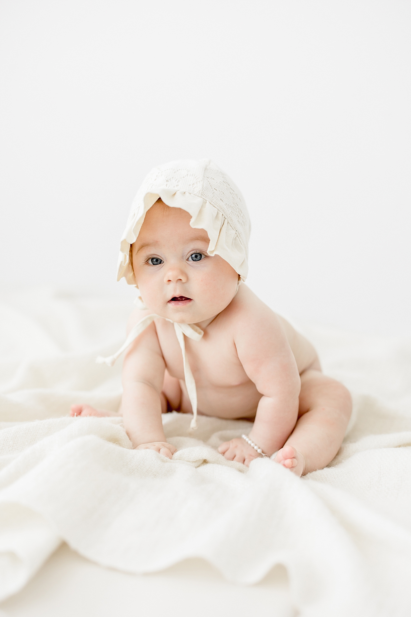 Six month old baby girl sitting up for milestone photos. Photo by Brittany Elise Photography.