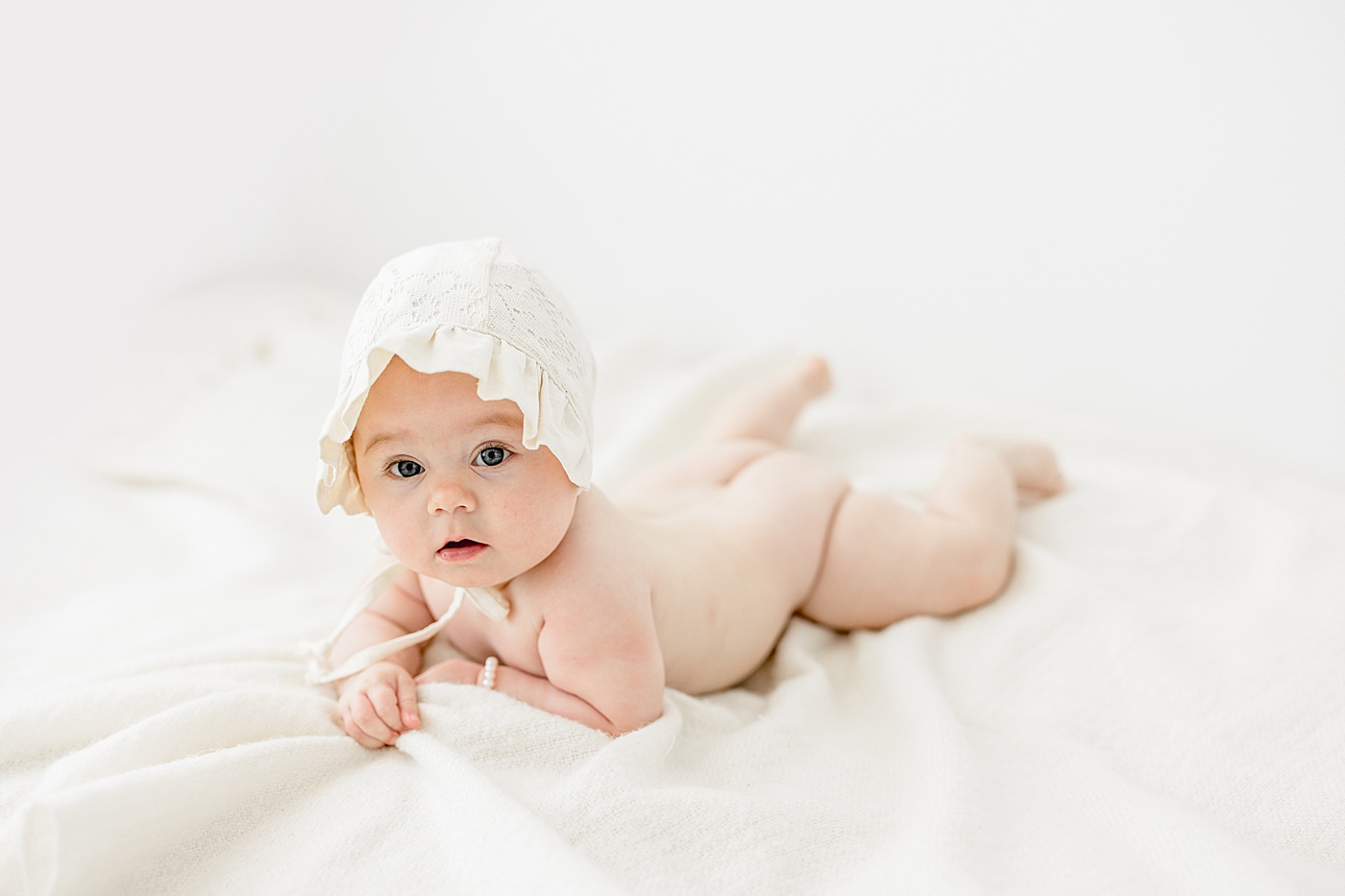 Six month old baby girl laying on her stomach. Photo by Brittany Elise Photography.