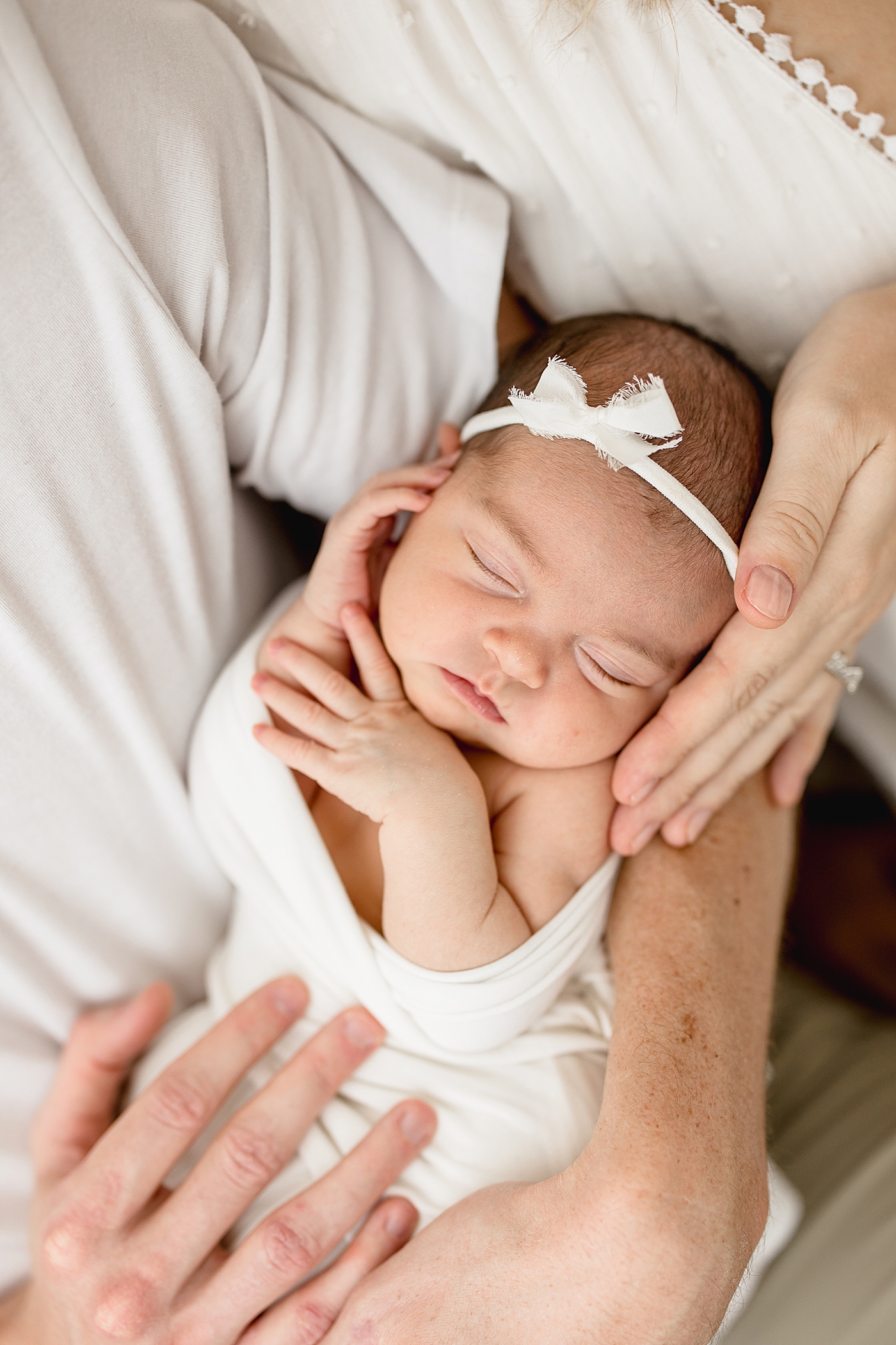 Mom and Dad holding their baby girl in their arms. Photo by Brittany Elise Photography.