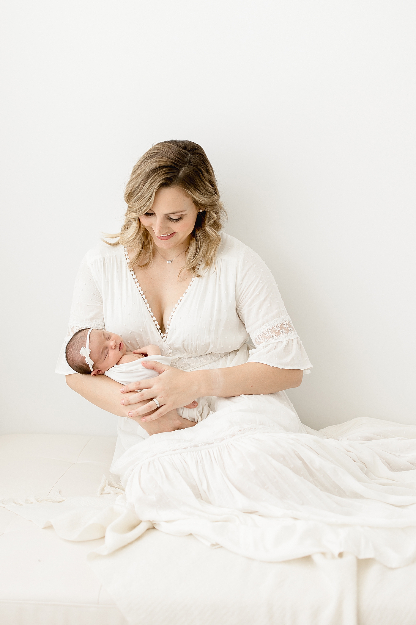 Mom with baby girl. Both are wearing white. Photo by Brittany Elise Photography.