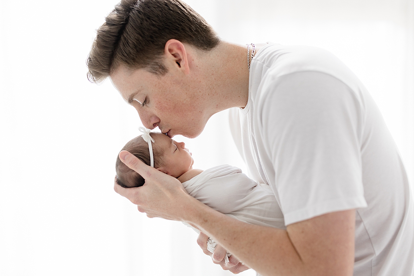 Dad giving baby girl a kiss. Photo by Brittany Elise Photography.