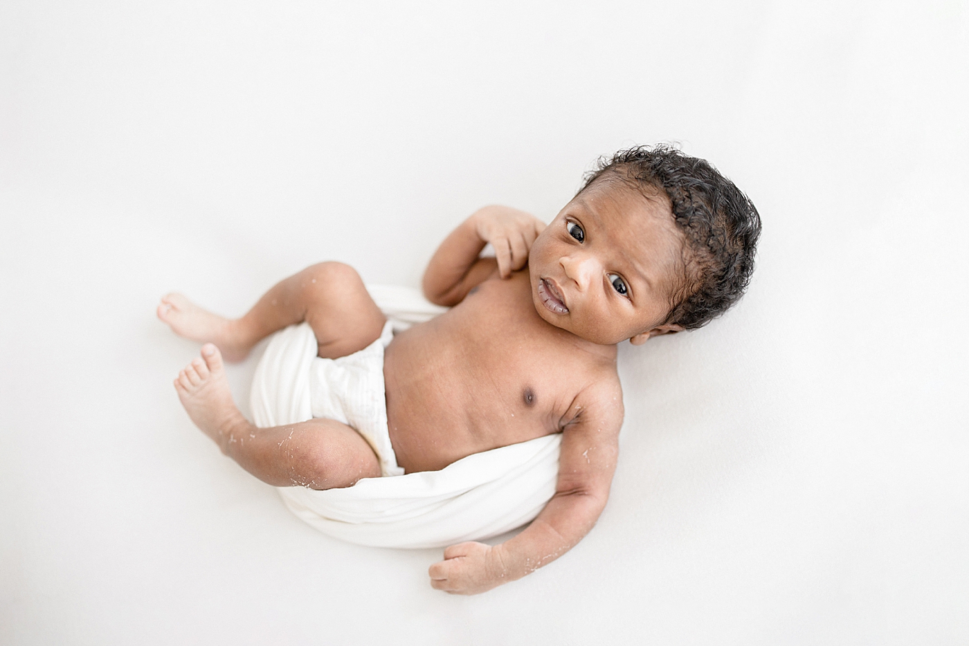 Baby boy wide awake for newborn photos. Photo by Brittany Elise Photography.