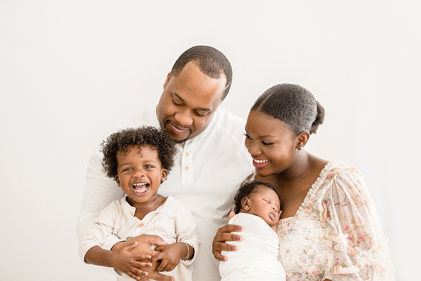 Family of four in studio in Tampa for newborn session. Photo by Brittany Elise Photography.